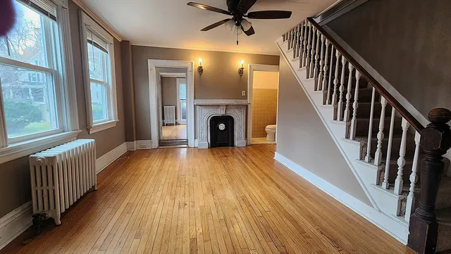 a view of a hallway with wooden floor fireplace and windows