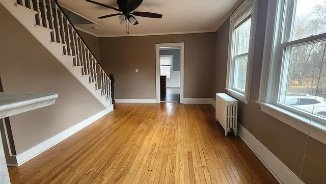 a view of a hallway with wooden floor and staircase