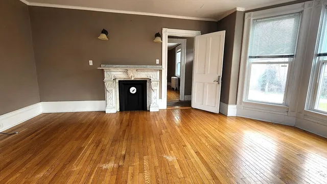 an empty room with windows and fireplace
