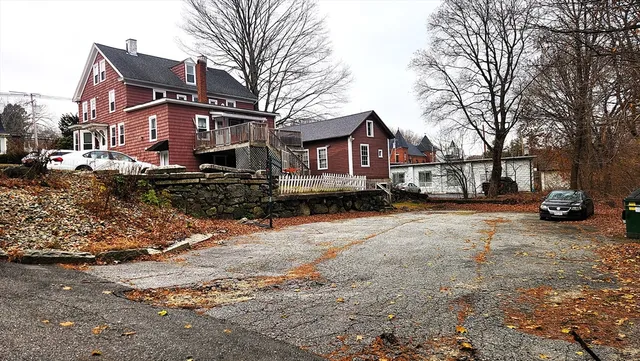 a front view of a house with a yard covered with snow