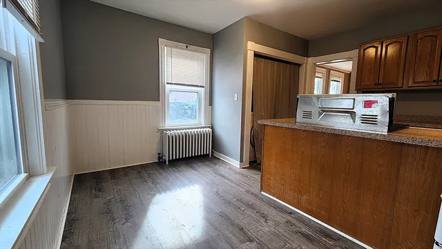 a view of kitchen with wooden floor and electronic appliances