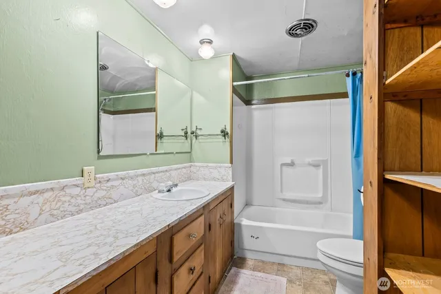 a bathroom with a granite countertop sink toilet and shower