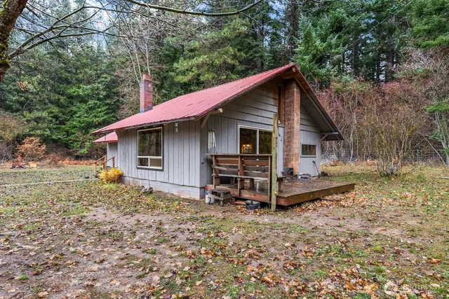 a view of a house with a yard chairs and iron fence