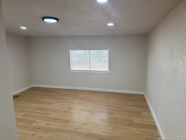 a view of an empty room with wooden floor