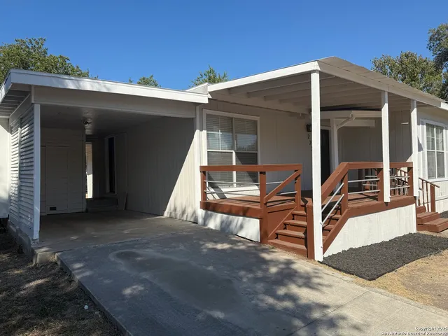 a view of a house with backyard and sitting area