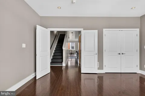 a view of a hallway with wooden floor and staircase