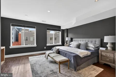 a spacious bedroom with a bed and wooden floor