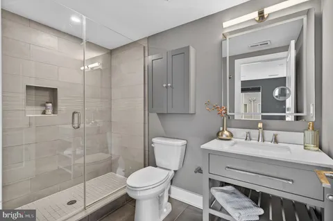 a bathroom with a sink toilet a mirror and shower