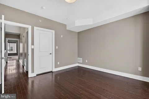 a view of an empty room with wooden floor