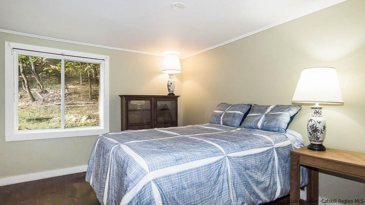 286 Rochester Center Road Kerhonkson, NY 12446 - Photo 32 of 34 a bedroom with a bed and a lamp