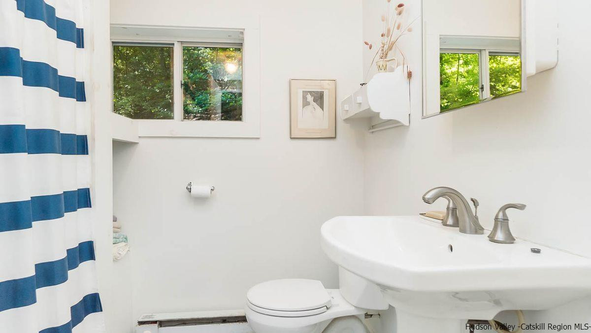286 Rochester Center Road Kerhonkson, NY 12446 - Photo 33 of 34 a bathroom with a sink a mirror and a toilet