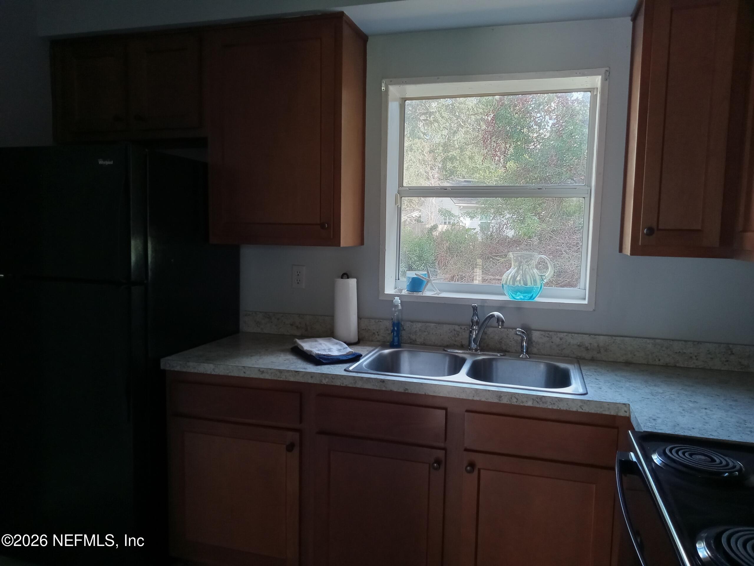 5527 Graywood Road Jacksonville, FL 32207 - Photo 4 of 12 a kitchen with a sink a window and cabinets