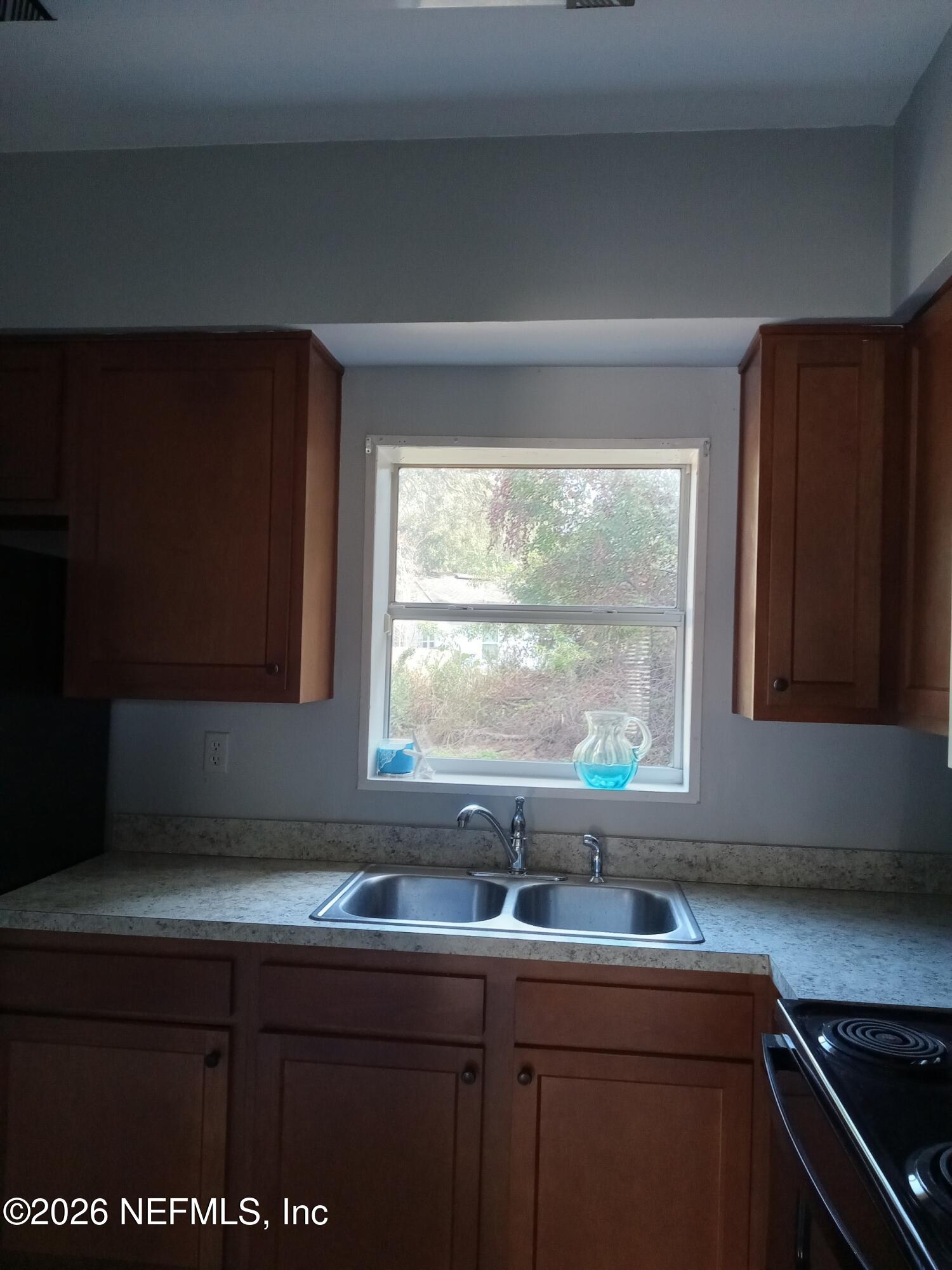 5527 Graywood Road Jacksonville, FL 32207 - Photo 6 of 12 a kitchen with a sink a window and cabinets