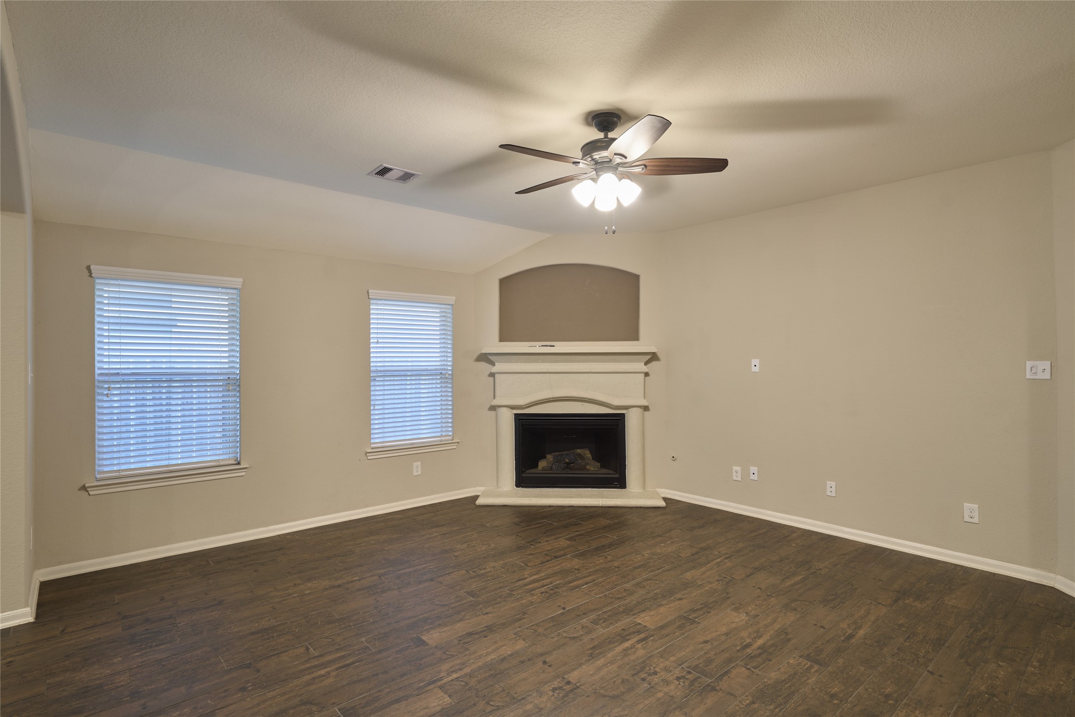 116 Fox Trail Road Montgomery, TX 77316 - Photo 13 of 50 The living area features a cozy fireplace, and tile floors. Natural light streams through two windows, creating a warm and inviting atmosphere.