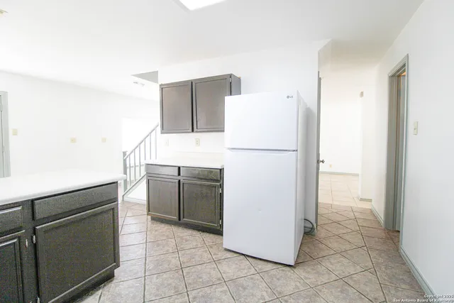 a white refrigerator freezer and a stove sitting inside of a kitchen