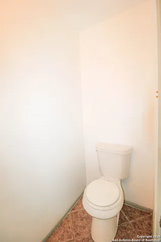 a white toilet sitting next to a white cabinet