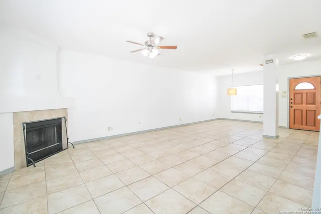 an empty room with fan and windows