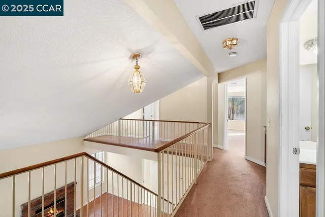 a view of staircase with railing and white walls
