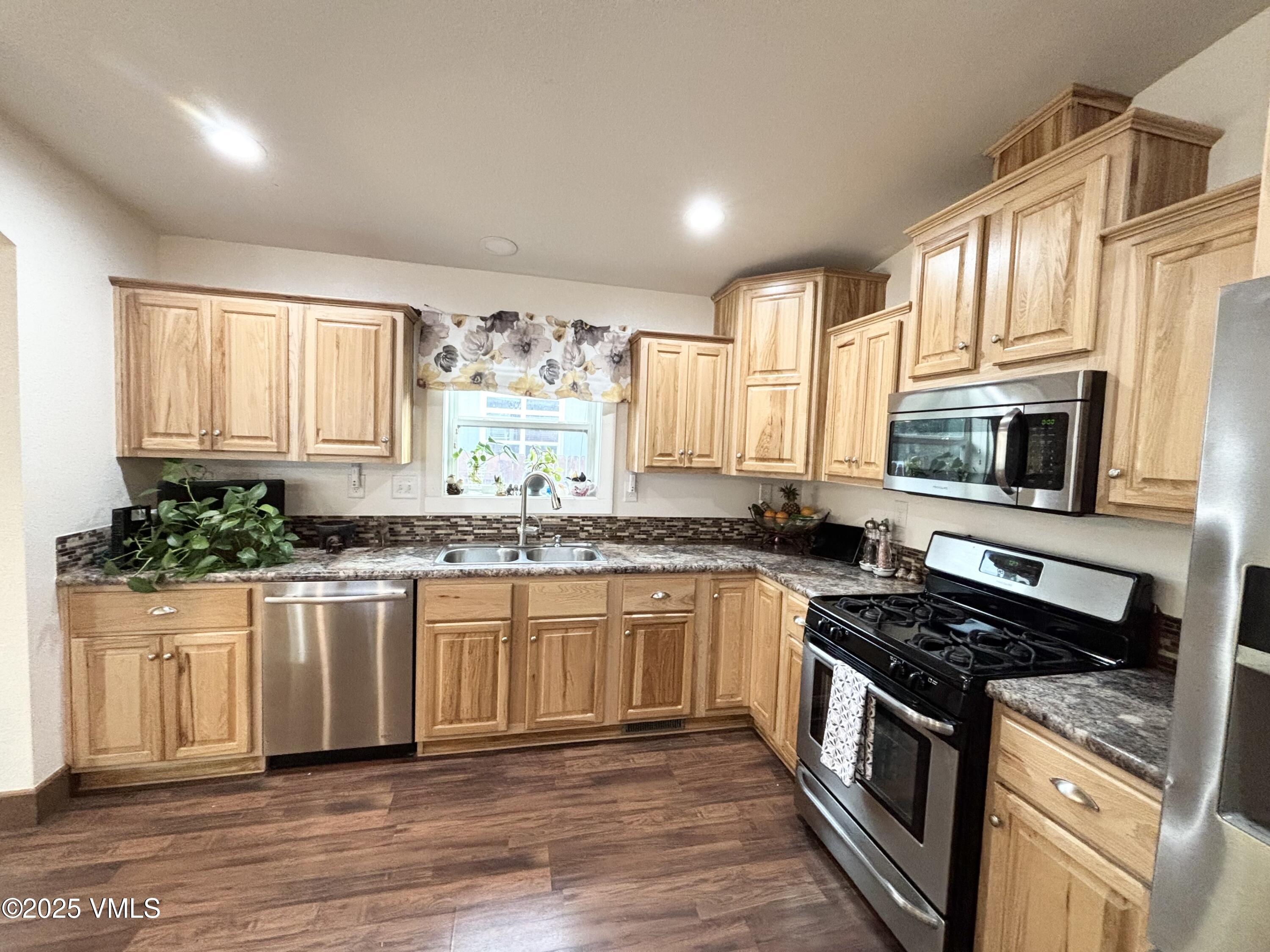 66 Bluegill Loop Gypsum, CO 81637 - Photo 10 of 37 a kitchen with stainless steel appliances granite countertop a stove a sink and a microwave