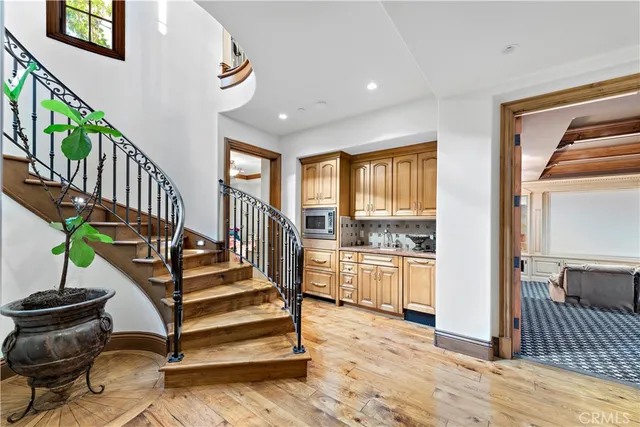 a view of a hallway with wooden floor and staircase
