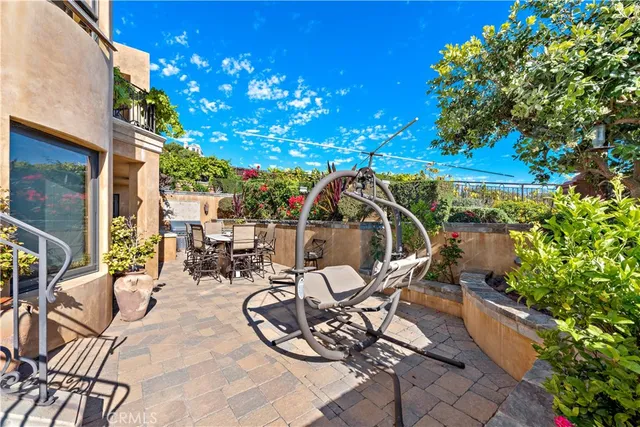 a view of a patio with table and chairs under an umbrella with a tree