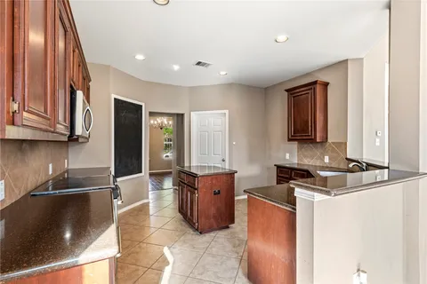 a large kitchen with stainless steel appliances granite countertop a sink stove and refrigerator