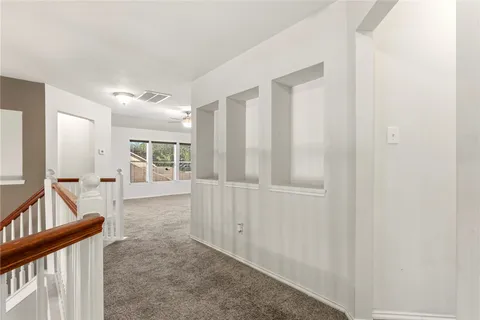 a view of a hallway with furniture and floor to ceiling window