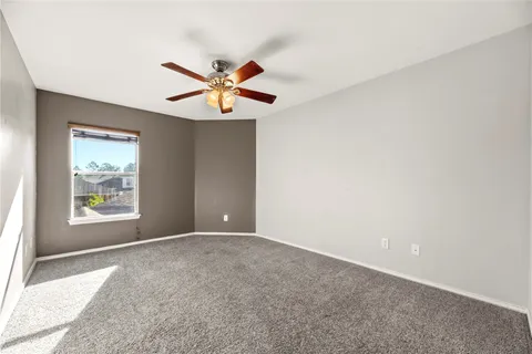an empty room with a window and a fan