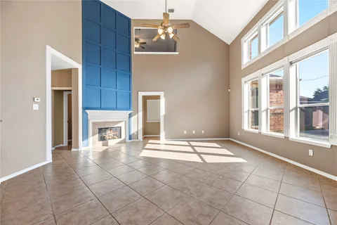 a view of an empty room with a fireplace and a window