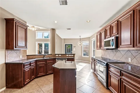 a kitchen with stainless steel appliances granite countertop a sink stove and cabinets