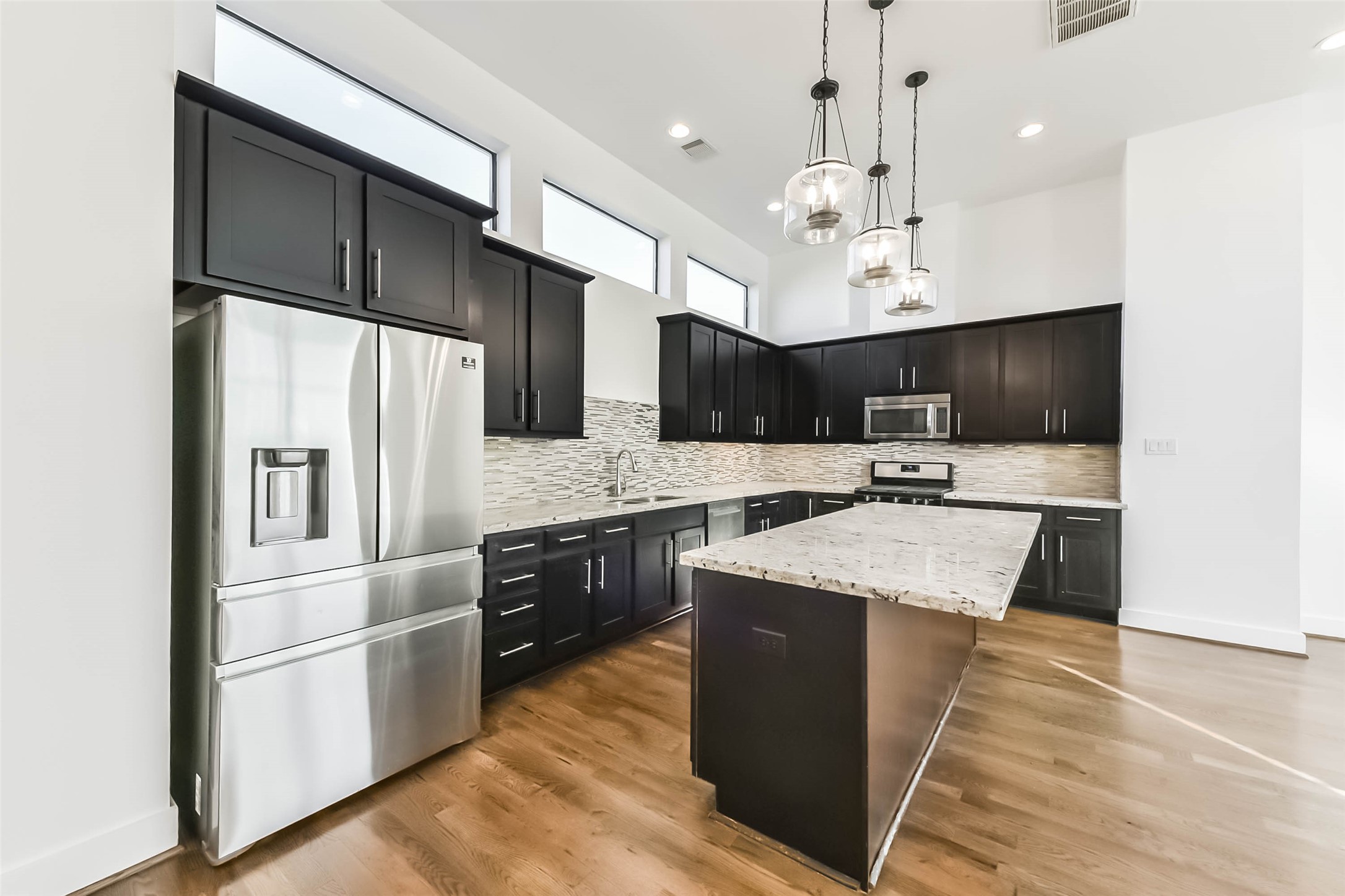 1810 Thompson Street Houston, TX 77007 - Photo 11 of 32 a kitchen with stainless steel appliances kitchen island granite countertop a refrigerator a sink dishwasher a stove and white cabinets with wooden floor