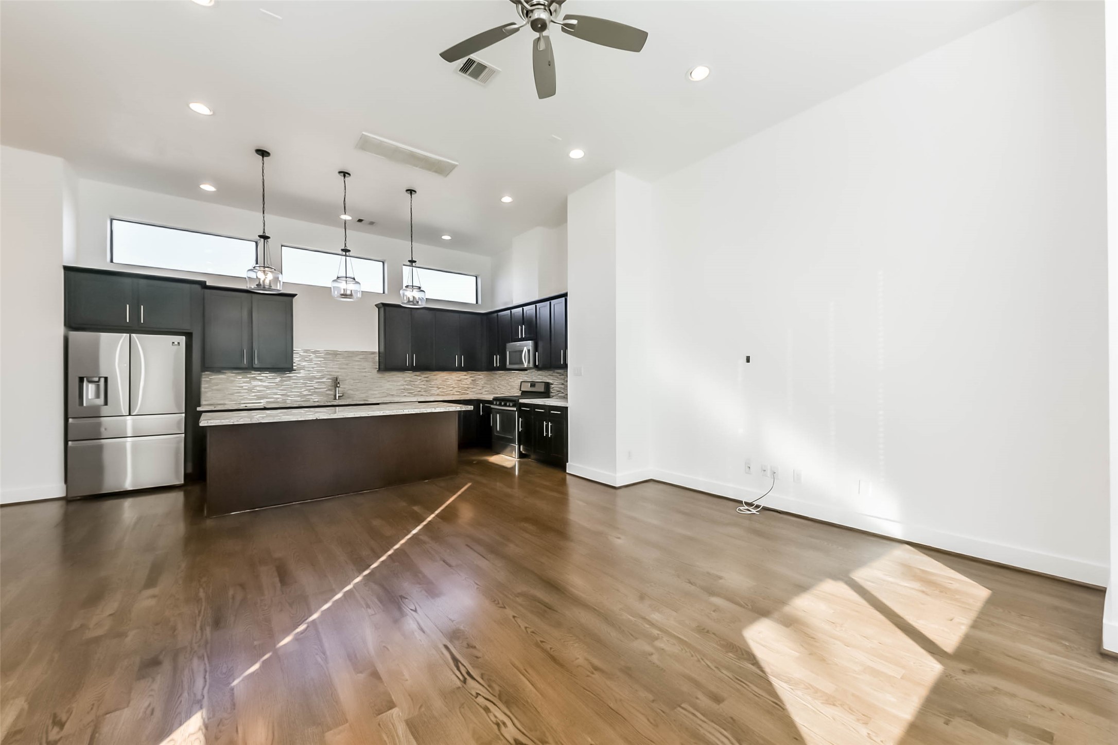 1810 Thompson Street Houston, TX 77007 - Photo 8 of 32 a large white kitchen with a refrigerator a sink dishwasher a stove and a dining table with wooden floor