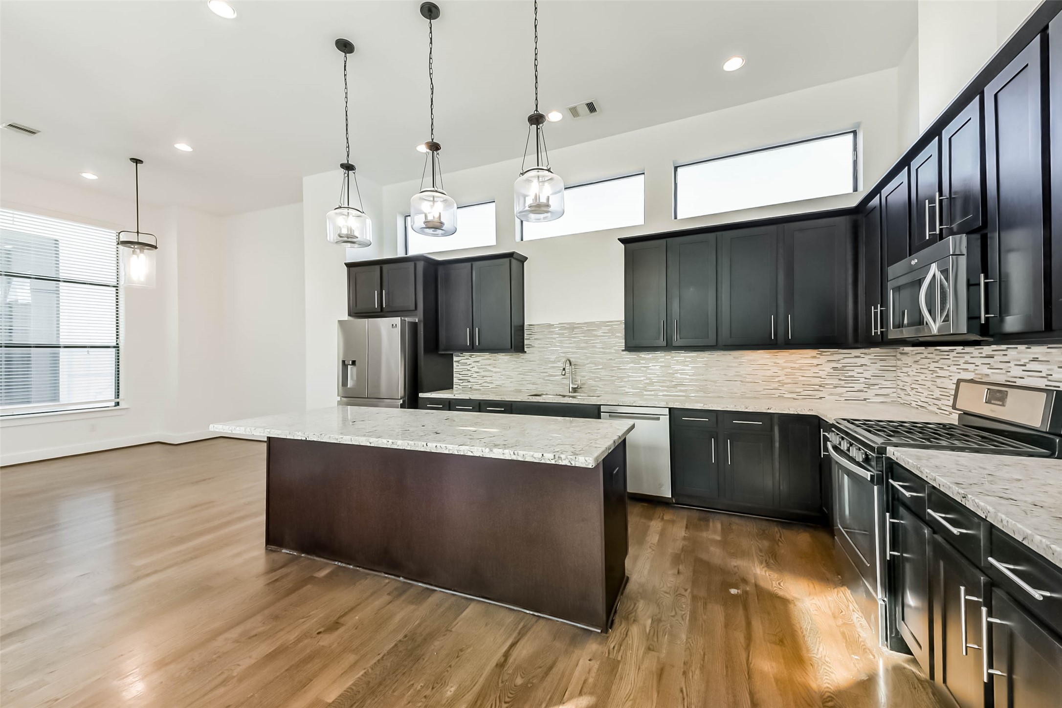 1810 Thompson Street Houston, TX 77007 - Photo 10 of 32 a kitchen with stainless steel appliances granite countertop a sink a stove and a wooden floors