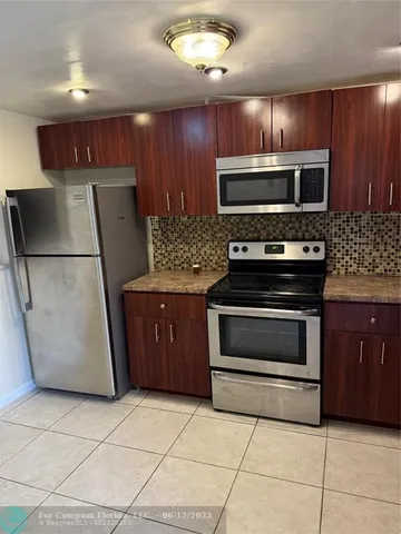 a kitchen with stainless steel appliances granite countertop a refrigerator stove and microwave