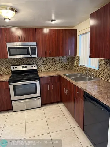 a kitchen with wooden cabinets a sink and stainless steel appliances