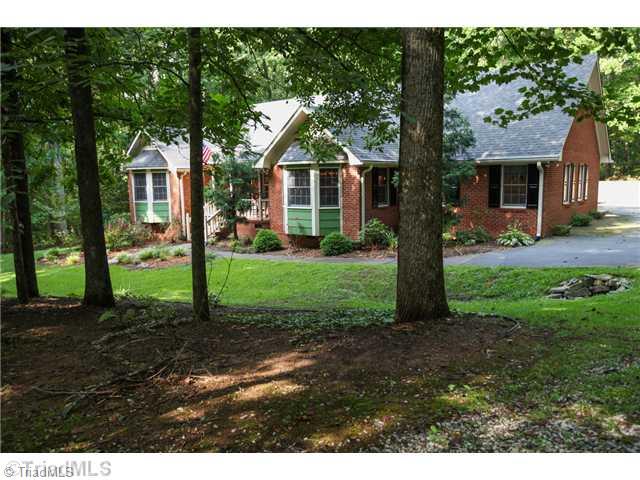 5401 Edgerunner Road Oak Ridge, NC 27310 - Photo 1 of 16 Exterior Front. Solid built all brick home with incredible frontage, numerous garden spaces and welcoming covered front porch.