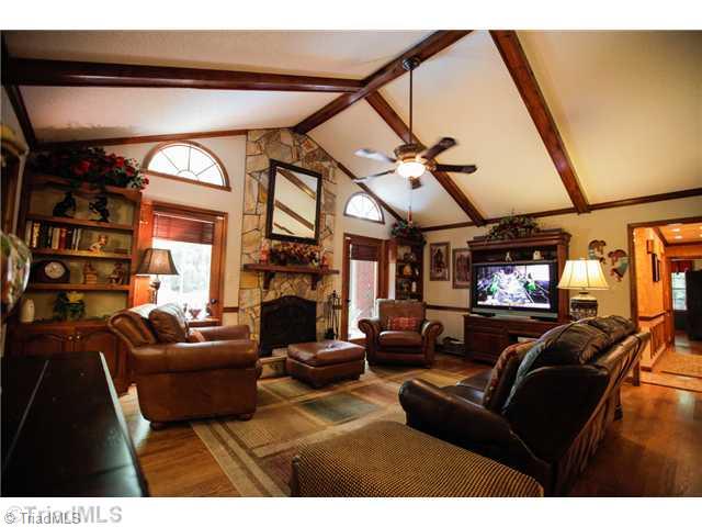 5401 Edgerunner Road Oak Ridge, NC 27310 - Photo 6 of 16 Living Room. Centrally located living room with built in bookshelf, cathedral ceiling and cozy stone surround fireplace.