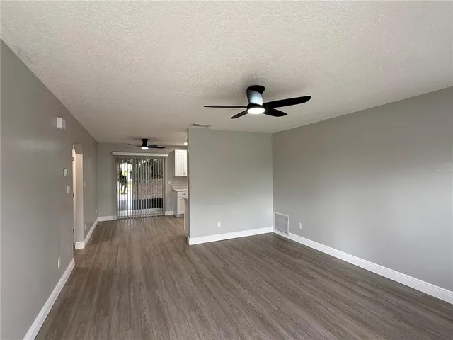 a view of empty room with wooden floor