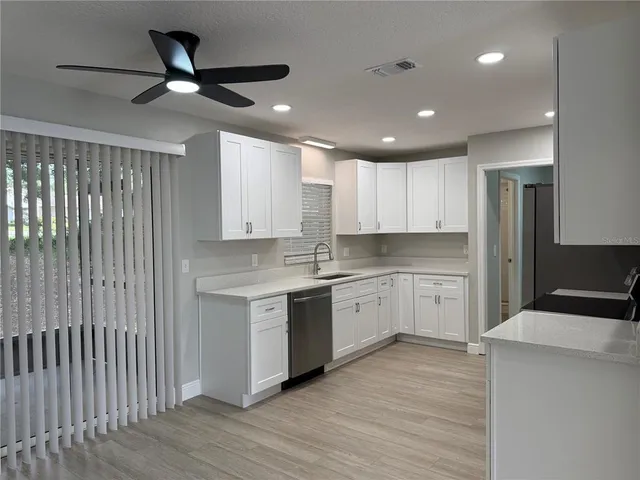 a kitchen with a sink window and stainless steel appliances