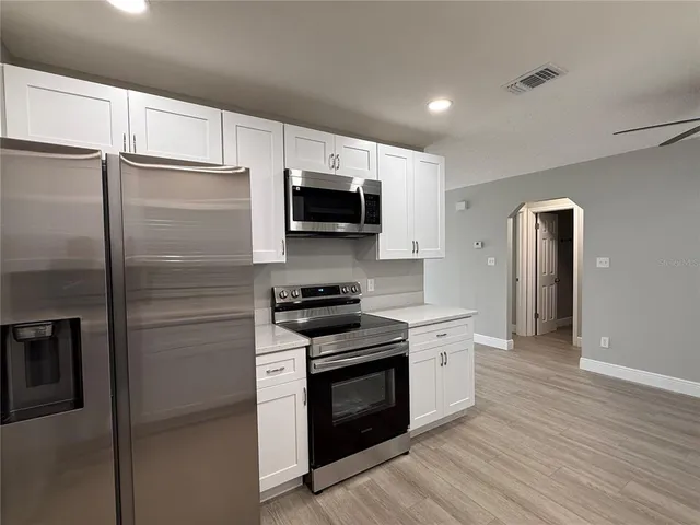 a kitchen with stainless steel appliances a refrigerator stove and microwave
