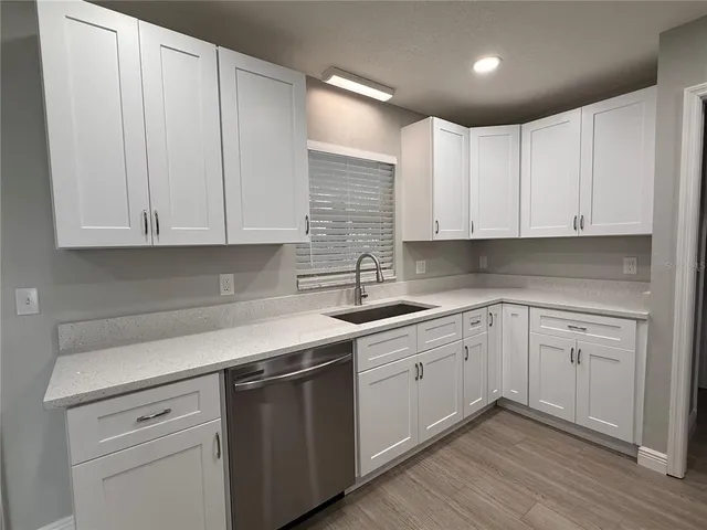 a kitchen with white cabinets stainless steel appliances and sink