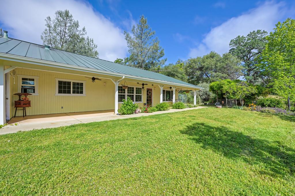 6181 Lambert Lane El Dorado, CA 95623 - Photo 7 of 68 rear view of property with a lawn, ceiling fan, covered porch, and a standing seam roof
