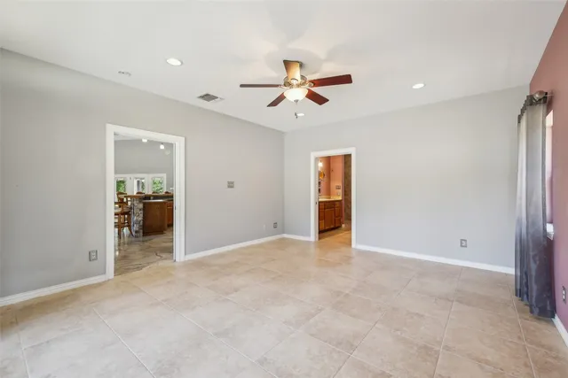 an empty room with closet and a ceiling fan