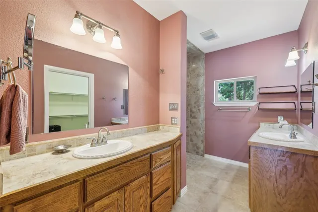 a bathroom with a granite countertop sink a large mirror and a shower