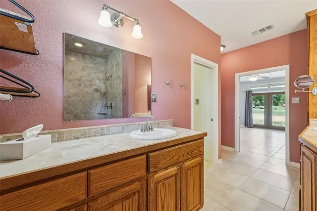 a bathroom with a sink a vanity and a large mirror