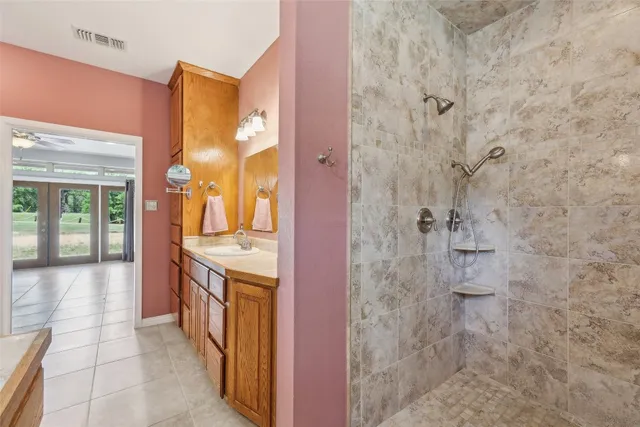 a bathroom with a granite countertop shower a sink and a mirror