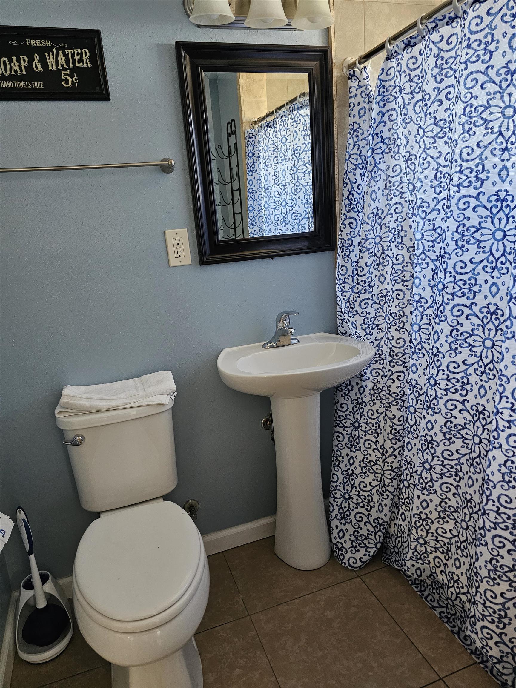 461 High Street Bishop, CA 93514 - Photo 10 of 10 Bathroom featuring a pedestal sink with chrome faucet, framed mirror, and a white toilet