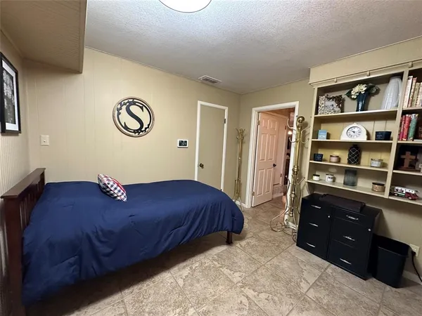 a bedroom with a bed and a book shelf