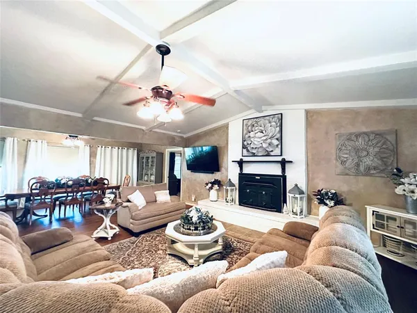 a living room with furniture kitchen view and a fireplace