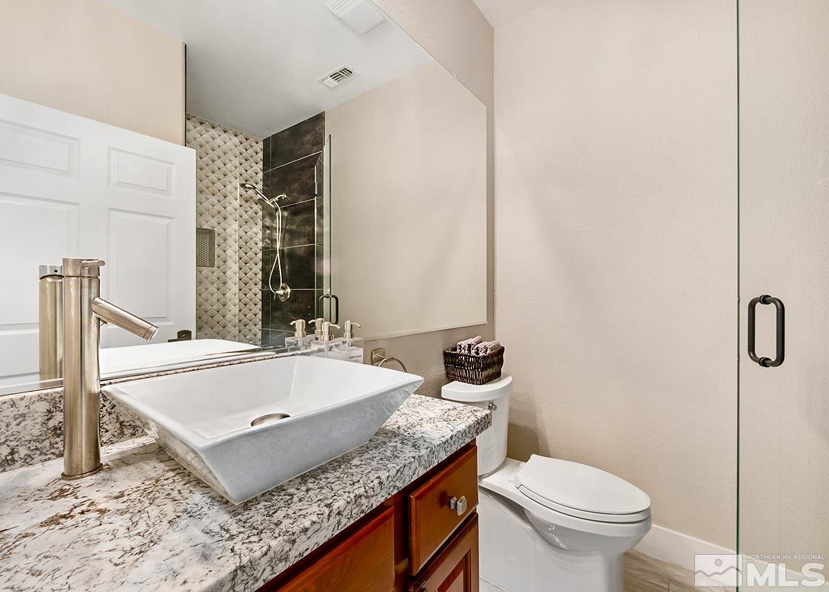 2552 Country Falls Lane Reno, NV 89521 - Photo 22 of 40 a bathroom with a granite countertop sink and a mirror